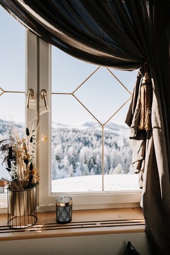 Ausblick aus dem Fenster in die verschneite Winterlandschaft