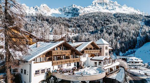 Ansicht vom Hotel Obereggen mit Bergpanorama im Winter