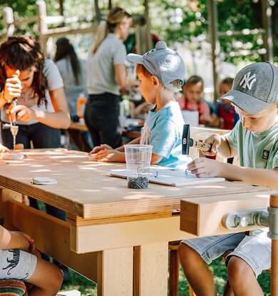 Kinderbetreuerin mit Kindern beim Basteln