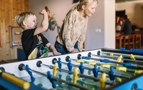 Kinder beim Tischfußball in der Kinderbetreuung