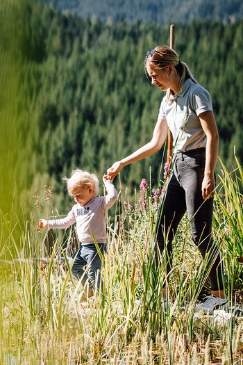 Frau mit Kind an der Hand beim Spaziergang