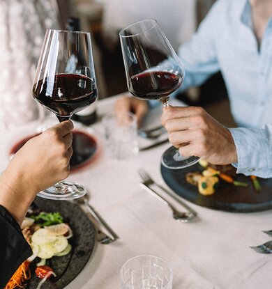 Pärchen beim Anstoßen mit Rotwein