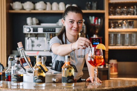 Kellnerin bereitet Aperol Spritz zu