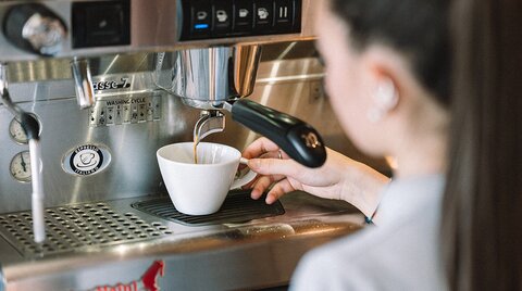 Kaffee fließt in eine Tasse