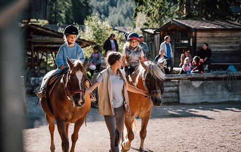 Reitlehrerin Lissy für zwei Pferde mit Reitschülern am Zügel