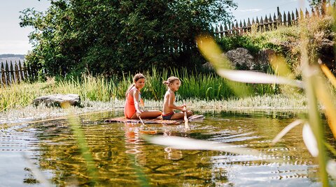 Kinder auf eine Floß im Bio-Schwimmteich