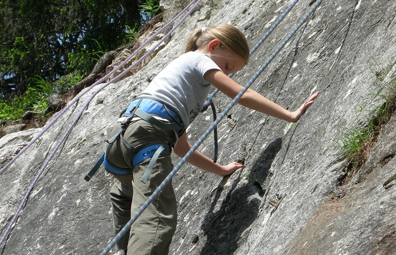 Kind beim Klettern am Fels