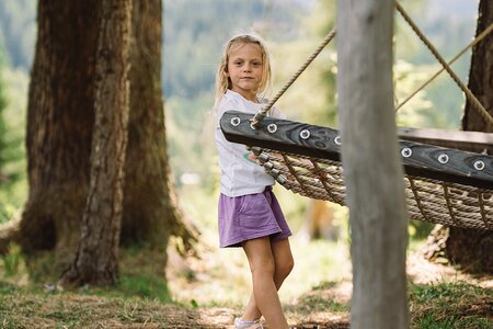 Kind auf den Schaukeln beim Spielplatz
