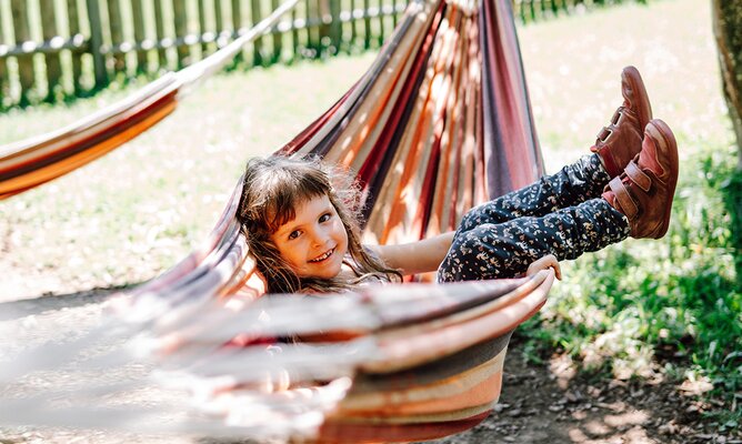 Kind in der Hängematte beim Spielplatz