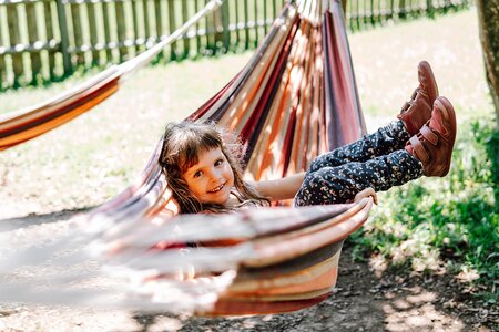 Kind in der Hängematte beim Spielplatz