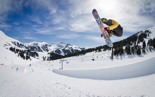 Snowboarder bei einem Sprung im Snowpark