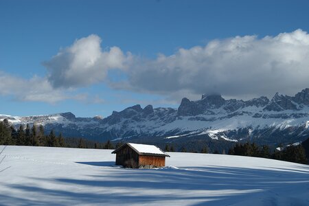 Hütte in winterlicher Umgebung vor Bergkulisse